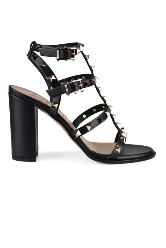 Sandalias Rockstud de Valentino en piel negra.Adornadas con tachuelas de acabado platino.Puntera redonda abierta.Correa al tobillo con hebilla ajustable.Altura del tacón: 9 cm.Piel de becerro.Made in Italy.
