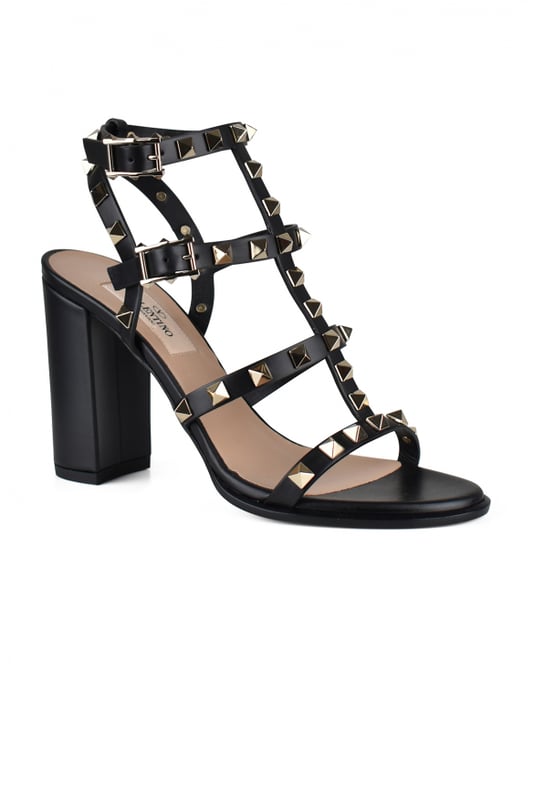 Sandalias Rockstud de Valentino en piel negra.Adornadas con tachuelas de acabado platino.Puntera redonda abierta.Correa al tobillo con hebilla ajustable.Altura del tacón: 9 cm.Piel de becerro.Made in Italy.