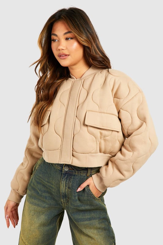 Quilted design for added texture and warmth
        Cropped length for a trendy silhouette
        Ribbed collar and cuffs for a snug fit
        Front zip closure for easy wear
        Functional front pockets for practicality
    
    This gesteppte Bomberjacke from Boohoo is the perfect blend of style and comfort for the fashion-forward woman. The quilted design not only adds visual interest but also provides extra warmth for those chilly days. Its cropped length is ideal for showcasing high-waisted trousers or skirts, creating a balanced and modern look. Style it with wide-leg jeans and trainers for a casual day out, or dress it up with a midi skirt and ankle boots for a night on the town. The versatile nature of this jacket makes it a go-to piece for various occasions, from casual meetups with friends to laid-back family gatherings. Its timeless appeal ensures it will remain a staple in your wardrobe for seasons to come, easily adaptable to the latest trends while maintaining its classic bomber jacket charm.