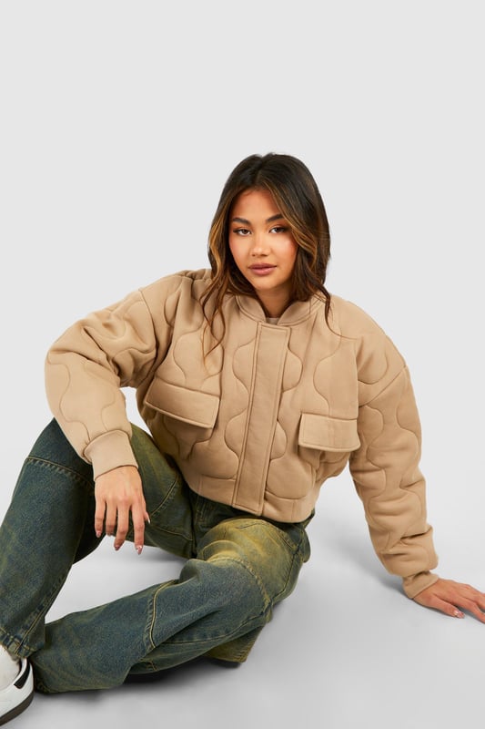 Quilted design for added texture and warmth
        Cropped length for a trendy silhouette
        Ribbed collar and cuffs for a snug fit
        Front zip closure for easy wear
        Functional front pockets for practicality
    
    This gesteppte Bomberjacke from Boohoo is the perfect blend of style and comfort for the fashion-forward woman. The quilted design not only adds visual interest but also provides extra warmth for those chilly days. Its cropped length is ideal for showcasing high-waisted trousers or skirts, creating a balanced and modern look. Style it with wide-leg jeans and trainers for a casual day out, or dress it up with a midi skirt and ankle boots for a night on the town. The versatile nature of this jacket makes it a go-to piece for various occasions, from casual meetups with friends to laid-back family gatherings. Its timeless appeal ensures it will remain a staple in your wardrobe for seasons to come, easily adaptable to the latest trends while maintaining its classic bomber jacket charm.