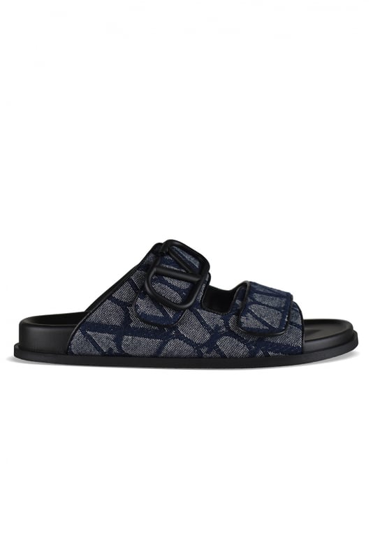 Sandalias Valentino de piel y lona azul marino.Lona iconográfica con logotipo monograma en contraste.Ribete con logo V en azul marino.Cierre delantero de velcro.Suela de goma.Made in Italy.