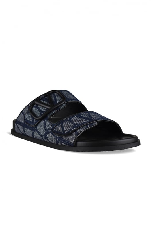 Sandalias Valentino de piel y lona azul marino.Lona iconográfica con logotipo monograma en contraste.Ribete con logo V en azul marino.Cierre delantero de velcro.Suela de goma.Made in Italy.