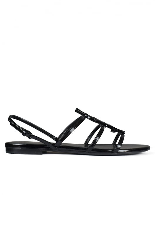 Sandalias Saint Laurent Cassandra en charol negro.Correas finas y hebilla ajustable.Iniciales de YSL en metal negro con piedras negras brillantes.Suela de cuero.Made in Italy.