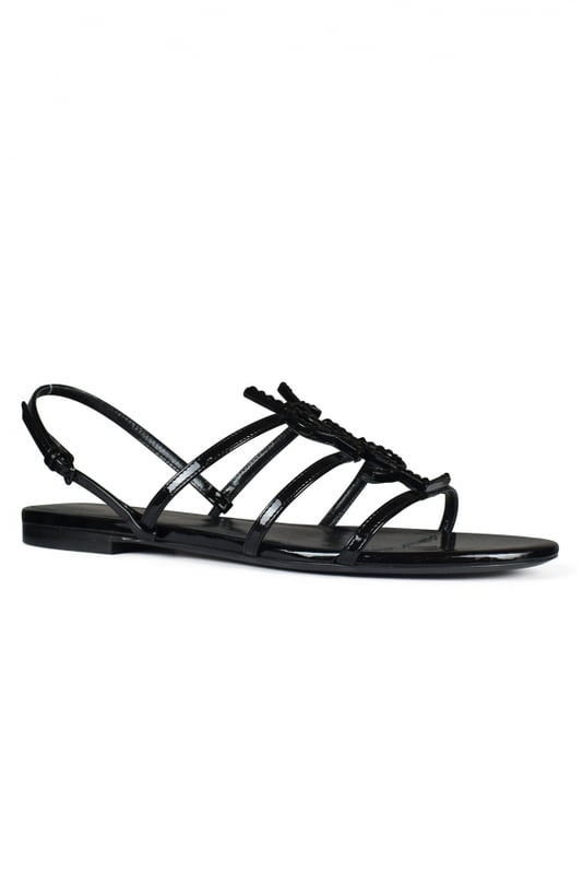 Sandalias Saint Laurent Cassandra en charol negro.Correas finas y hebilla ajustable.Iniciales de YSL en metal negro con piedras negras brillantes.Suela de cuero.Made in Italy.