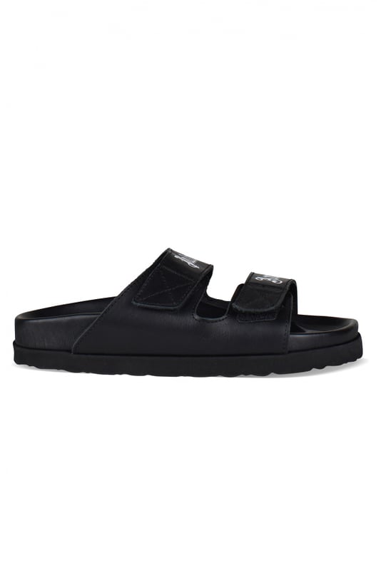 Sandalias Palm Angels de piel negra.Tiras de piel negra con logotipo blanco.Cierre de velcro.Suela plana de goma.Made in Italy.