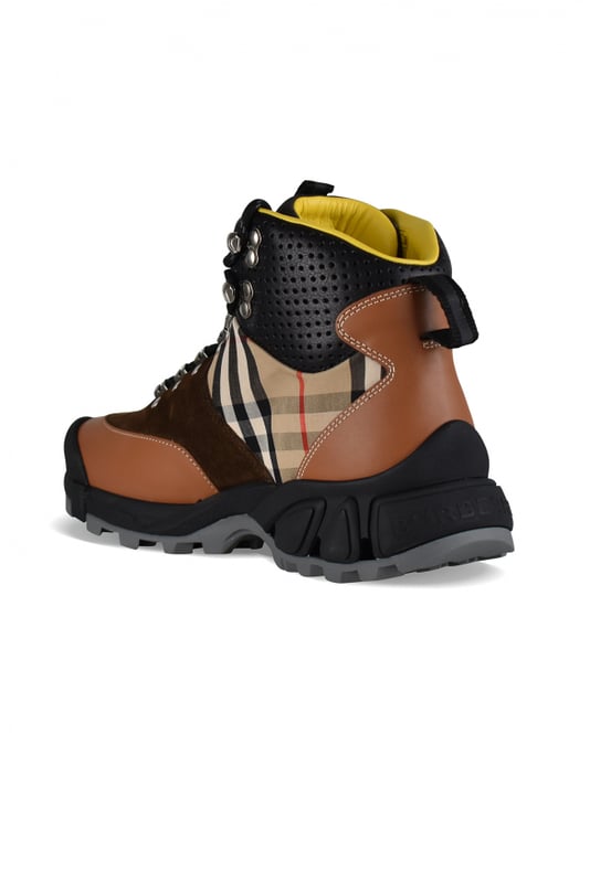 Botines Arthur Burberry de piel y ante marrón.Cierre delantero con cordones negros.Ojales reforzados.Logotipo «TB» en el exterior.Inserto de lona a cuadros Burberry.Hebilla trasera.Suela de caucho negro.Inscripción «Burberry» en la parte trasera de la suela.Made in Italy.