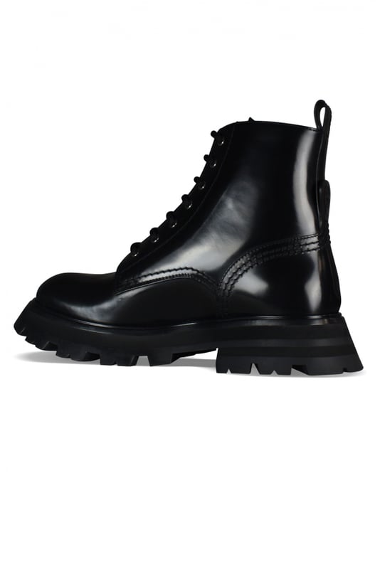 Botas con cordones Alexander McQueen Wander.Cuero negro.Relleno de piel de oveja.Detalle de la costura. Firma en la lengua.Lengüeta en la parte trasera.Sello del logotipo de Alexander McQueen en relieve en el talón.Punta redonda.Suela de goma gruesa negra.Made in Italy.