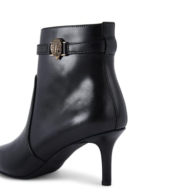 This Kurt Geiger Kensington Flexi Ankle boot features a sleek black leather upper with pointed toe. There is an antiqued brass eagle head on the slim ankle strap. Heel height: 6.5cm.