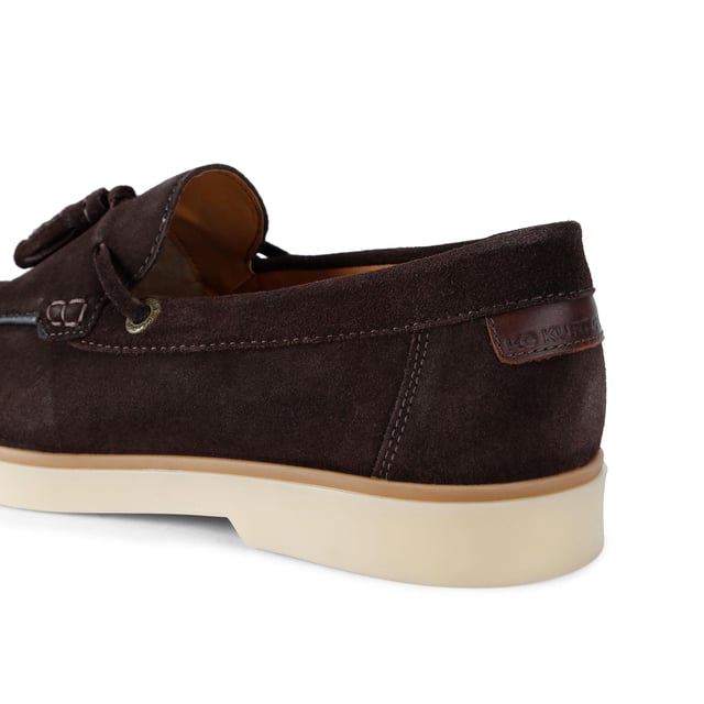 KG Kurt Geiger Suede Ronan Slip On The KG Kurt Geiger Ronan is a slip-on shoe crafted from a brown suede leather. There are antiqued brass branded eyelets on each side with a tassel detail on the toe.
