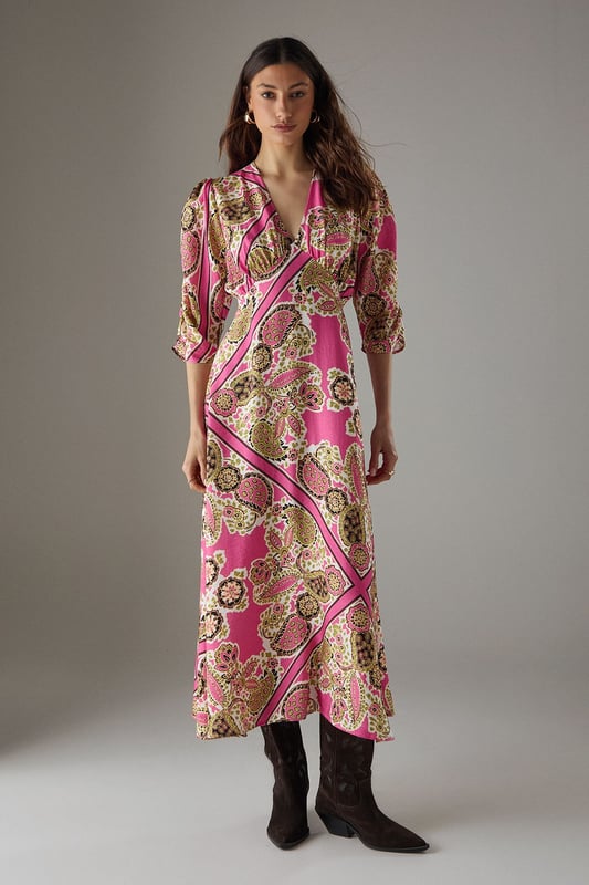 Striking paisley print midi dress with elegant V-neckline
        Feminine puff sleeves with three-quarter length for a flattering silhouette
        Flowing viscose fabric that drapes beautifully around the body
        Midi length design perfect for versatile styling options
        Subtle waist definition that enhances the feminine shape
    
    This Warehouse paisley midi dress captures confident femininity with its bold print and flattering cut. The V-neckline frames the dcolletage beautifully, while the puff sleeves add a touch of romantic charm to this contemporary piece. Style with western boots for an edgy daytime look as shown, or switch to flat sandals for relaxed weekend brunches. The flowing viscose fabric moves gracefully with every step, making it ideal for family gatherings or casual social events. For cooler days, layer with a cropped denim jacket and add statement earrings to complement the distinctive pattern. This versatile dress transitions effortlessly from day to evening - simply swap your casual footwear for block heels and add a clutch bag for dinner dates. The midi length offers the perfect balance of comfort and style for the modern British woman.