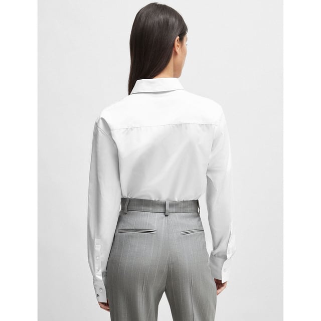 Womens NAOMI x BOSS Cotton Bodysuit in white.An effortless bodysuit with blouse styling by BOSS Womenswear  crafted in cotton and topped with a point collar. Specially designed with a wrinkle-free  bacteria-resistant finish. Part of an exclusive capsule  co-created with Naomi Campbell  designed with elegance  confidence  and on-the-go ease in mind. - Point collar- Long sleeves- Button cuffs- Main material: 100% Cotton.  Lower part: 91% Polyamide  9% Elastane.  Hand wash - Dry clean.- Ref: 50515405-100