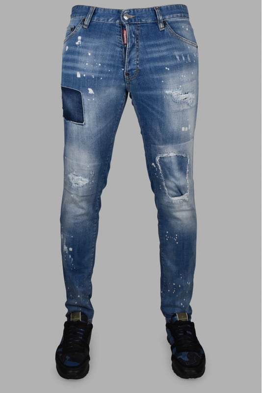 Vaqueros Dsquared2 Cool Guy de algodón azul.Efecto lavado y distressed.Manchas de pintura blanca.Ligeras roturas.Etiqueta roja con logotipo en la bragueta.Parche trasero marrón con palmeras y letras rojas.Cierre con botones.Trabillas.Cinco bolsillos, 2 de ellos traseros.Corte recto.