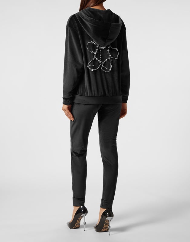 con cristales  Lo que ve no es un chándal de jogging cualquiera, sino la prueba de que el estilo de Plein puede personalizar cada momento de su día. Descubra más.   Suave terciopelo de chenilla elástica   Sudadera con capucha y cremallera   El icónico osito Teddy de strass en la espalda   Bolsillos con aberturas   Cintura con cordón de ajuste   Hexágono PP en un parche de cuero saffiano tanto en la parte superior como en la inferior    Dobladillos de punto elástico