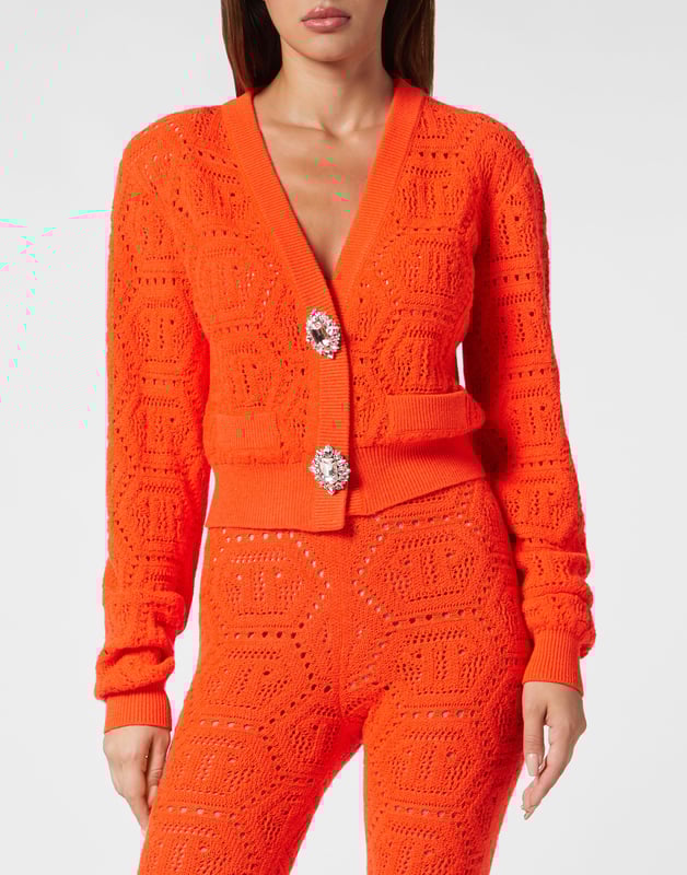 Einzigartigkeit und Stil finden sich auch in einer Strickjacke. Sehen Sie sich diese Version an, die aus einem weichen, fluoreszierenden Baumwollmischgarn hergestellt wurde. Erfahren Sie mehr.   Gestrickte Baumwollmischung   Monogramm mit Spitzenstich ganzflächig gestrickt    Schmuckbroschen imitieren einen Knopfverschluss   Gepolsterte Schultern   Zwei Rippstrickkanten imitieren zwei Taschen   Rippstrick-Säume