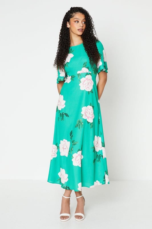 Vibrant floral print adorns this woven midi dress
Flattering round neckline and flutter sleeves
Relaxed fit through the bodice
Midi length hits below the knee
woven fabric with a lightweight feel

Embrace the season's botanical trend with this eye-catching floral midi dress. The vibrant print and flutter sleeves exude a feminine charm, perfect for daytime occasions like brunches or family gatherings. Style it with trainers or sandals for a relaxed yet polished look that transitions seamlessly from day to night.