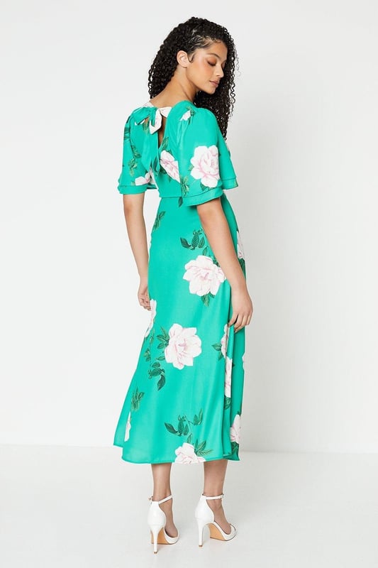 Vibrant floral print adorns this woven midi dress
Flattering round neckline and flutter sleeves
Relaxed fit through the bodice
Midi length hits below the knee
woven fabric with a lightweight feel

Embrace the season's botanical trend with this eye-catching floral midi dress. The vibrant print and flutter sleeves exude a feminine charm, perfect for daytime occasions like brunches or family gatherings. Style it with trainers or sandals for a relaxed yet polished look that transitions seamlessly from day to night.