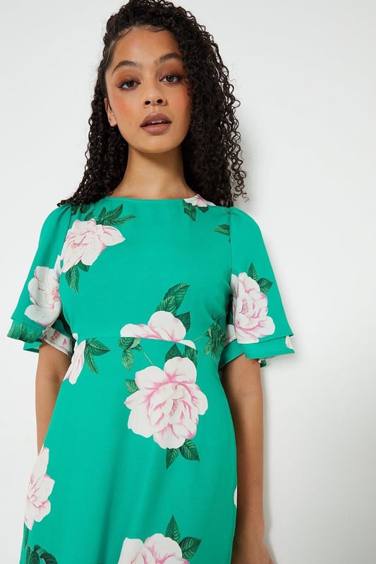 Vibrant floral print adorns this woven midi dress
Flattering round neckline and flutter sleeves
Relaxed fit through the bodice
Midi length hits below the knee
woven fabric with a lightweight feel

Embrace the season's botanical trend with this eye-catching floral midi dress. The vibrant print and flutter sleeves exude a feminine charm, perfect for daytime occasions like brunches or family gatherings. Style it with trainers or sandals for a relaxed yet polished look that transitions seamlessly from day to night.