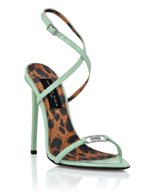 Muestre su lado valiente y a la moda con las sandalias de charol con tira en el tobillo. Eche un vistazo a los detalles.   Parte superior de charol   Logotipo joya en la tira de la puntera   Correa cruzada con hebilla   Suela de piel auténtica   Forro interior   Tacón forrado de 12 cm