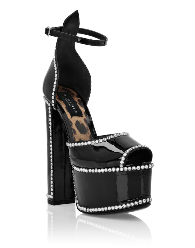 Maak je zomer uniek met deze plateausandalen met open teen... Bekijk de details.   Bejeweled lak bovenwerk   Gesp enkelbandje   12 cm gevoerde hoge blokhakken en 4 cm plateau   Jewel Skull op leren zool   Gevoerde binnenkant en voetbed