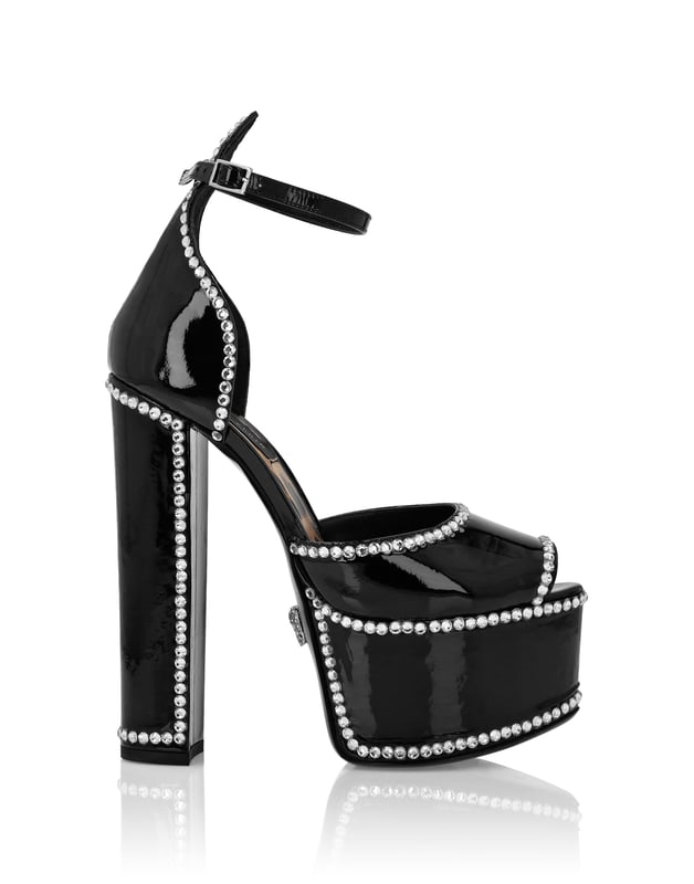 Maak je zomer uniek met deze plateausandalen met open teen... Bekijk de details.   Bejeweled lak bovenwerk   Gesp enkelbandje   12 cm gevoerde hoge blokhakken en 4 cm plateau   Jewel Skull op leren zool   Gevoerde binnenkant en voetbed