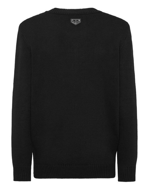 Este juguetón y lujoso jersey de cuello redondo captura la esencia de la sofisticación informal con un toque de fantasía, con un llamativo motivo de osito de peluche.    Confeccionado en una mezcla de algodón y lana de primera calidad para ofrecer calidez y comodidad.   El icónico diseño de osito añade un detalle único y llamativo.   Los ribetes acanalados proporcionan un acabado refinado y mejoran la durabilidad.   Ideal para añadir una pieza divertida y llamativa a cualquier conjunto informal.   Suficientemente versátil para llevar solo o en capas para los días más fríos.