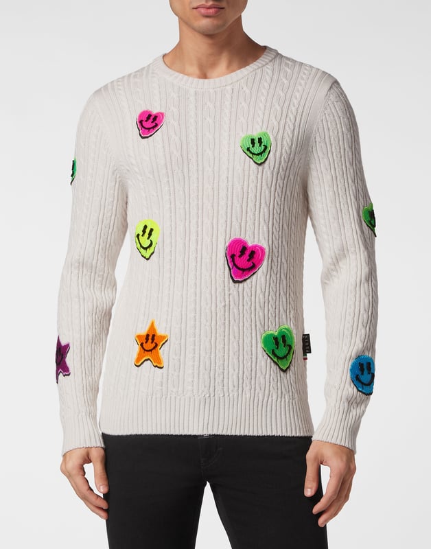Innovación y creatividad son las raíces del estilo de Plein. Descubra las características de este original jersey de lana de cuello redondo.    Punto de cable de lana merino    Insignias bordadas cosidas por toda la prenda    Marca bordada en la espalda    Hexágono PP en un parche de piel saffiano cosido en el canesú    Dobladillos de punto elástico