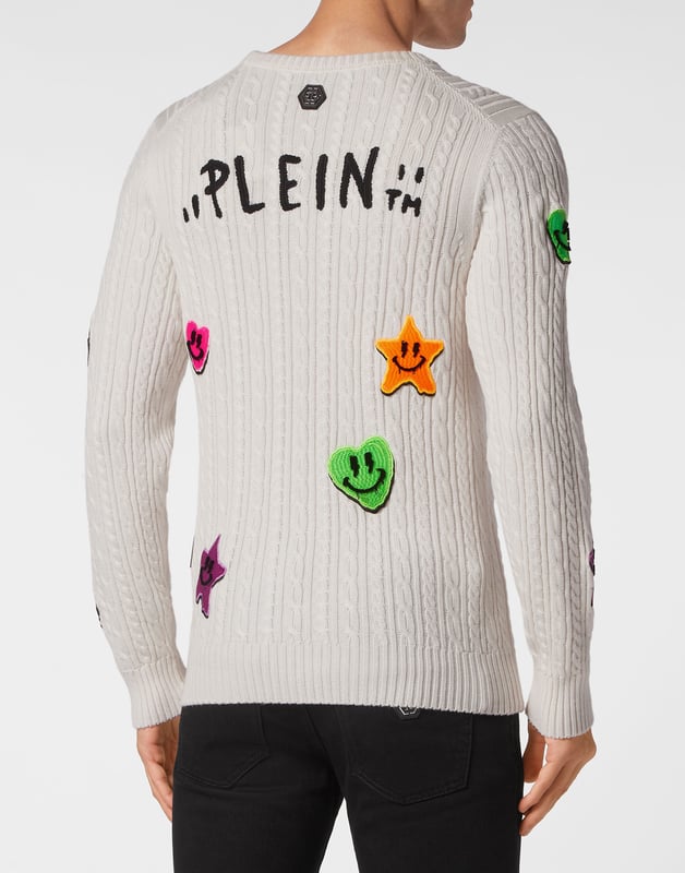 Innovación y creatividad son las raíces del estilo de Plein. Descubra las características de este original jersey de lana de cuello redondo.    Punto de cable de lana merino    Insignias bordadas cosidas por toda la prenda    Marca bordada en la espalda    Hexágono PP en un parche de piel saffiano cosido en el canesú    Dobladillos de punto elástico