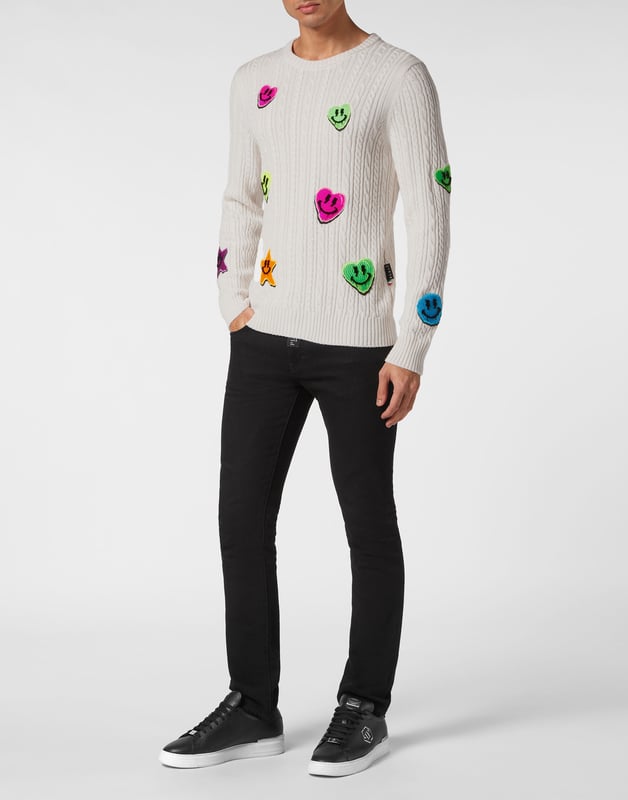 Innovación y creatividad son las raíces del estilo de Plein. Descubra las características de este original jersey de lana de cuello redondo.    Punto de cable de lana merino    Insignias bordadas cosidas por toda la prenda    Marca bordada en la espalda    Hexágono PP en un parche de piel saffiano cosido en el canesú    Dobladillos de punto elástico