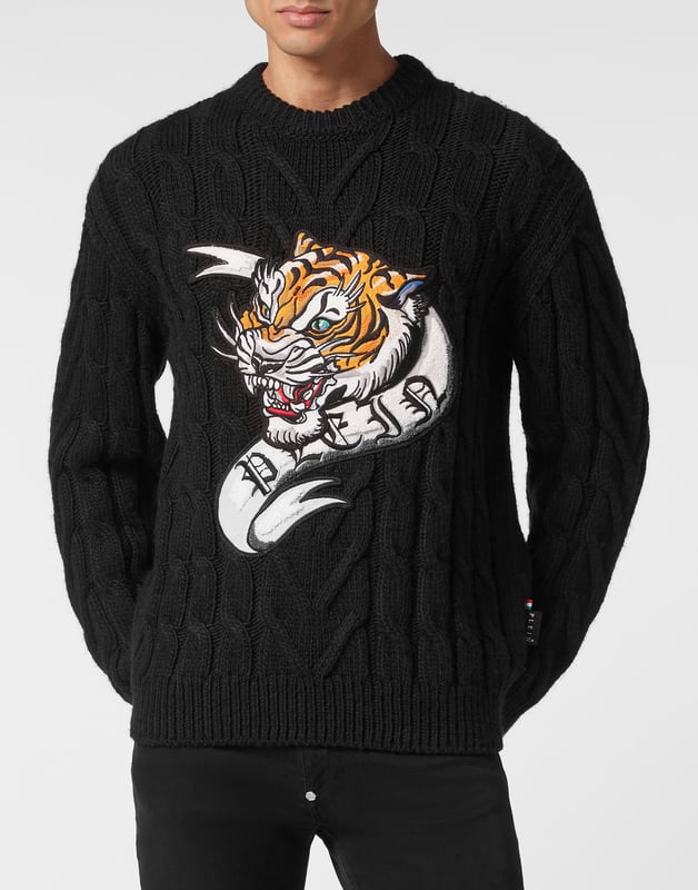 Innovación y creatividad son las raíces del estilo de Plein. Descubra las características de este original jersey de lana de cuello redondo.   Mezcla de lana tejida con cables de galga 7.   Parche bordado cosido en la parte delantera   Etiqueta con logotipo cosida en el canesú   Dobladillos de punto elástico
