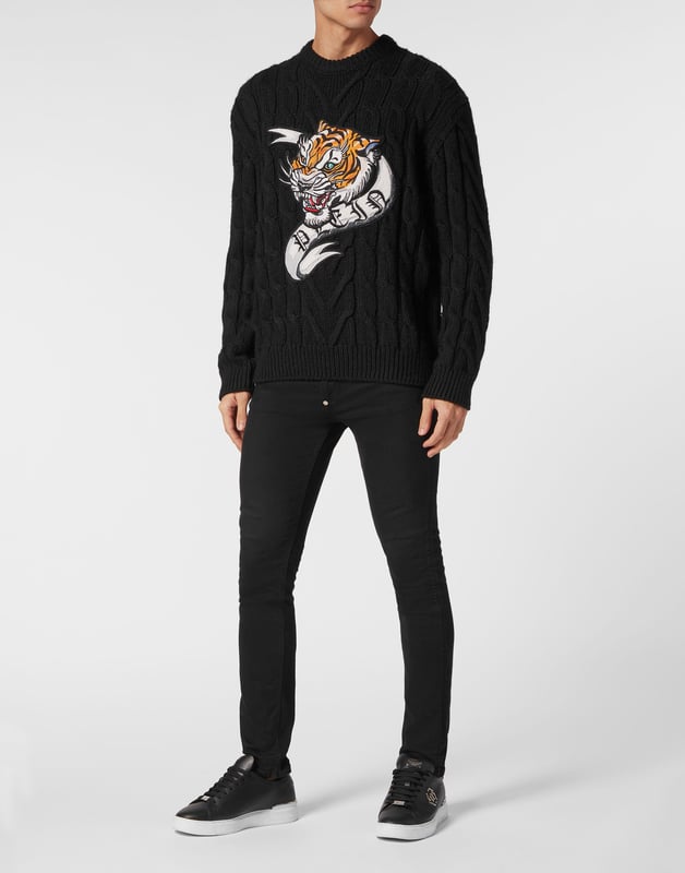 Innovación y creatividad son las raíces del estilo de Plein. Descubra las características de este original jersey de lana de cuello redondo.   Mezcla de lana tejida con cables de galga 7.   Parche bordado cosido en la parte delantera   Etiqueta con logotipo cosida en el canesú   Dobladillos de punto elástico