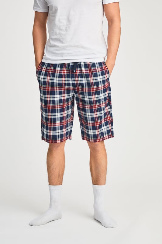 These Tokyo Laundry boxer-style checked lounge shorts are made from 100% cotton with a garment-washed finish for ultimate comfort. Designed with an elastic waistband and adjustable drawstring, they offer a relaxed fit, making them perfect for everyday lounging. Stylish, breathable, and effortlessly casual.