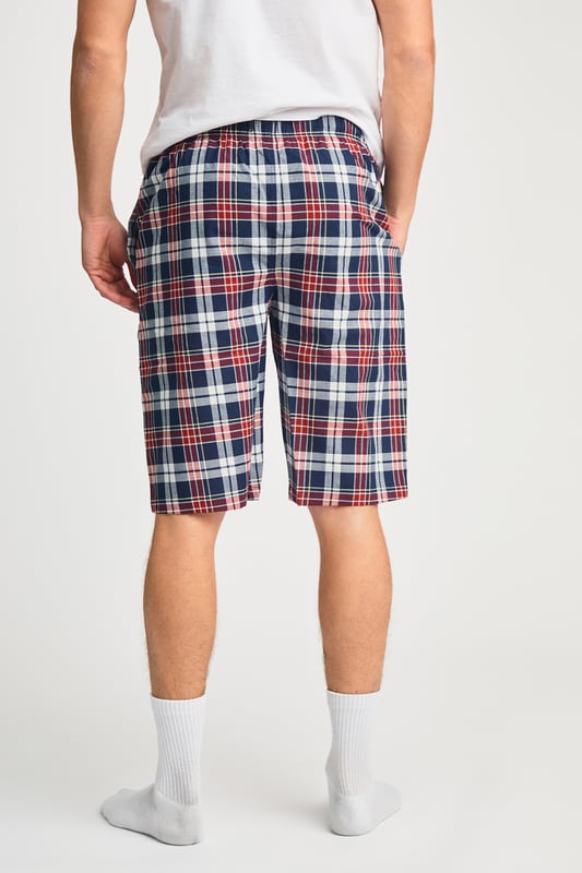 These Tokyo Laundry boxer-style checked lounge shorts are made from 100% cotton with a garment-washed finish for ultimate comfort. Designed with an elastic waistband and adjustable drawstring, they offer a relaxed fit, making them perfect for everyday lounging. Stylish, breathable, and effortlessly casual.