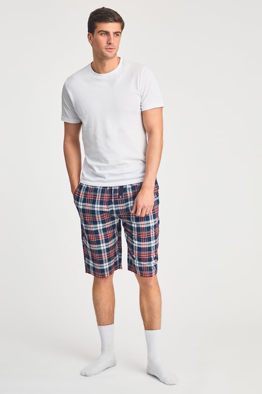 These Tokyo Laundry boxer-style checked lounge shorts are made from 100% cotton with a garment-washed finish for ultimate comfort. Designed with an elastic waistband and adjustable drawstring, they offer a relaxed fit, making them perfect for everyday lounging. Stylish, breathable, and effortlessly casual.