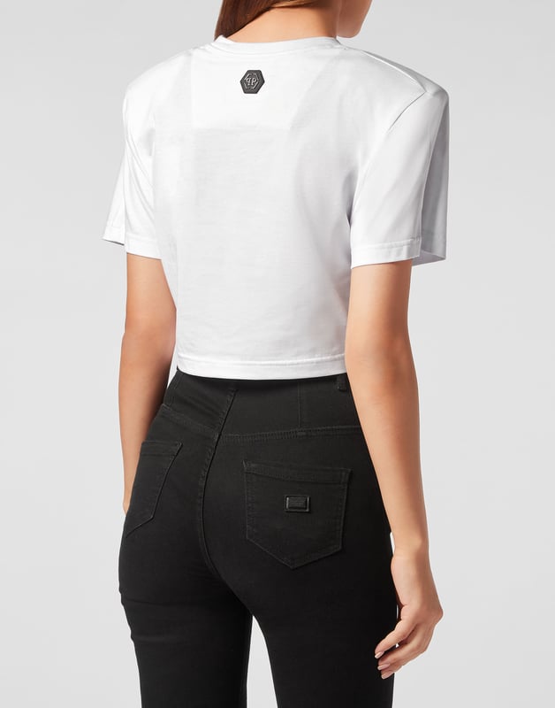 Añade una pizca de singularidad a tus conjuntos con esta camiseta crop de algodón. Fíjese en los detalles.   Punto de algodón   Los estampados de The Brand decoran la parte delantera y trasera   Acolchado en los hombros   Hexágono de PP en un parche de cuero saffiano cosido en el canesú   Escote de punto elástico   Costura a dos agujas    Ajuste: Cropped
