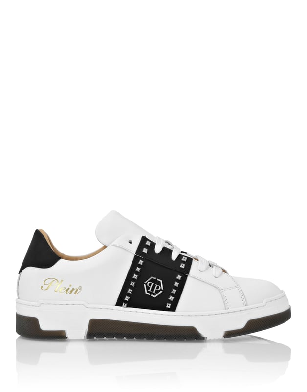 Discover the uniqueness of these lo-top sneakers with studs decoration. Look at the details.   Nappa upper    Rubber strap featuring studs and the nickel-plated logo   Contrasting colored heel tab   Nickel-plated spoiler on heel stabilizer   Hi-tech, ergonomic, ultra lightweight, shock-absorbing rubberized midsole   Grooved outsole for maximum grip   Padded nappa lining and removable insole