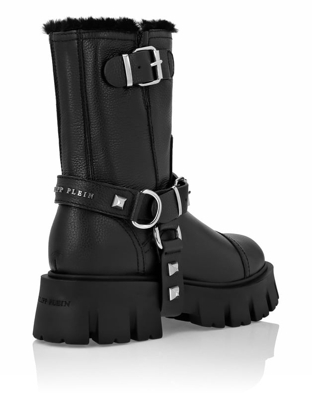 met studs  Geef je stijl een bikertintje met de leren laars in een nieuw jasje van Philipp Plein. Bekijk de eigenaardige verwerking en ontdek meer.    Hertenleer   Harnas en enkelband met studs en gespen   Rubberen lugzool voor maximale grip   Schapenvacht voering   Geweven label op voetbed