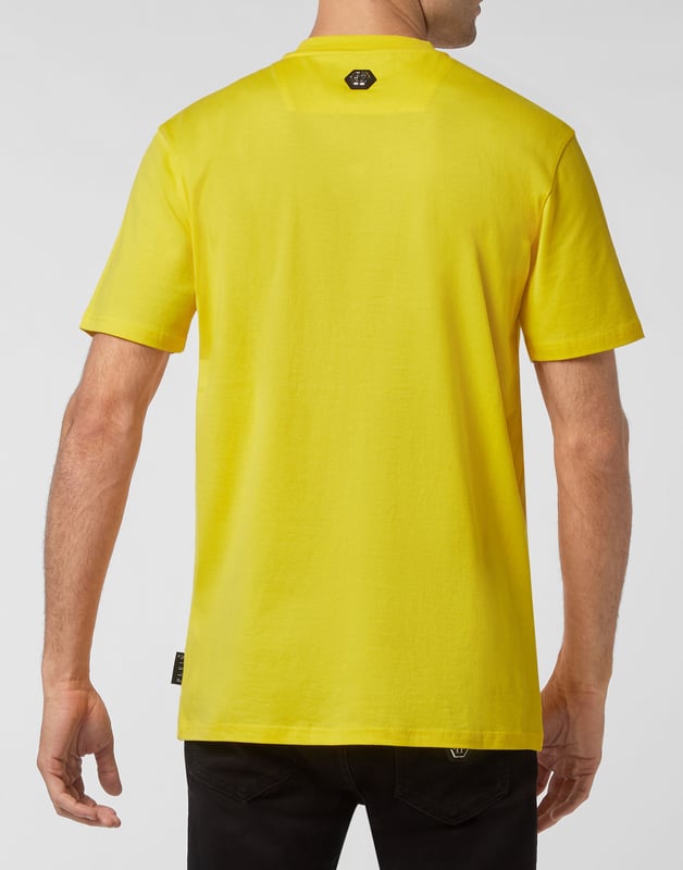 Mire cómo se transforma esta camiseta de jersey de algodón con cuello redondo. La prenda lleva el icónico estampado de las letras de la marca y una frase irónica al más puro estilo Plein. Un parche de cuero saffiano con el Hexágono PP está cosido en el canesú. Dobladillos de pespunte doble.