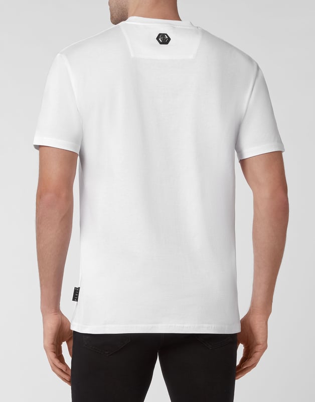 Mire cómo se transforma esta camiseta de jersey de algodón con cuello redondo. La prenda presenta la icónica calavera con aplicaciones de las letras de la marca. Un parche de cuero saffiano con el Hexágono PP está cosido en el canesú. Dobladillos de pespunte doble.