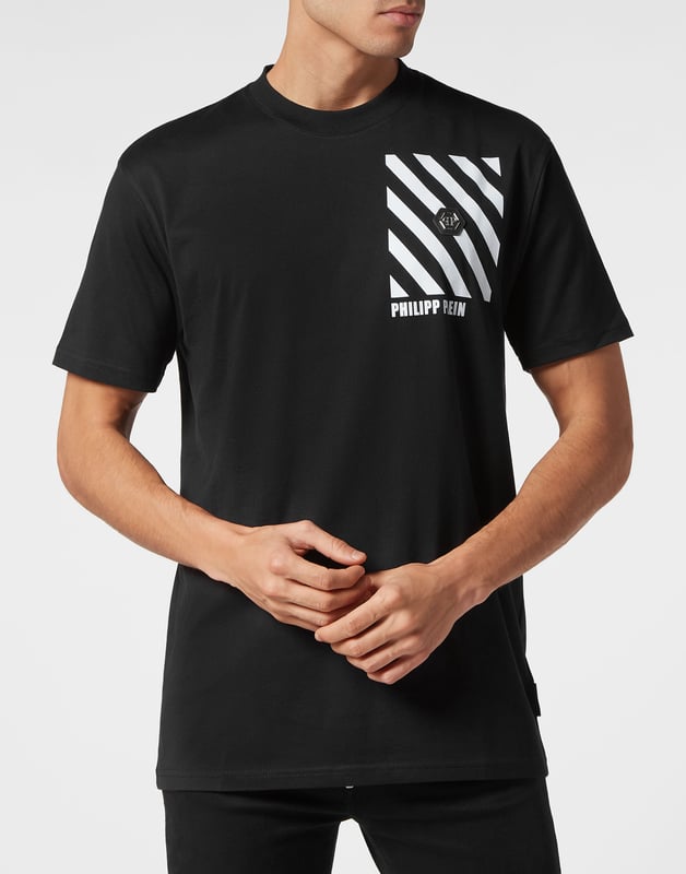 Dit gestroomlijnde t-shirt met ronde hals combineert eenvoud met opvallende graphics en geeft een eigentijdse draai aan alledaagse kleding.    Vervaardigd van hoogwaardig katoen voor een zachte, ademende pasvorm.   Onderscheidend gestreept ontwerp voegt een modern randje toe aan elke outfit.   Handtekeningmerk versterkt op subtiele wijze de minimalistische look.   Perfect om in laagjes of los te dragen en veelzijdigheid toe te voegen aan uw garderobe.   Moeiteloos te combineren met jeans of joggers voor een casual maar verfijnde stijl.  Dit T-shirt is een ideale keuze voor wie houdt van strakke lijnen en moderne esthetiek.