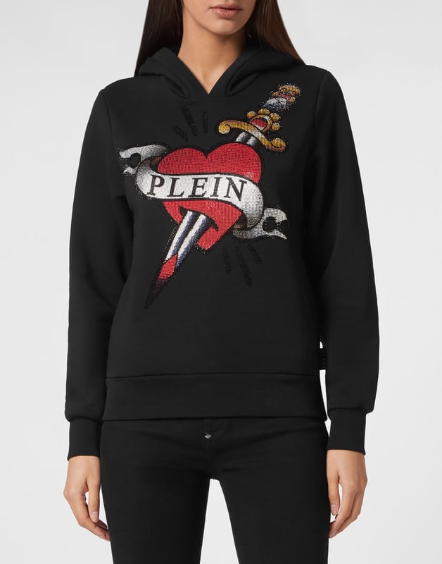 Descubra lo original que es esta sudadera con capucha de forro polar de algodón con estampados y aplicaciones.   Suave forro polar de algodón   Estampados con temática Love Tattoo con pedrería en la parte delantera   Hexágono PP en una insignia de cuero saffiano cosida encima de la capucha    Dos bolsillos con aberturas   Dobladillo de punto elástico   Ajuste: Over