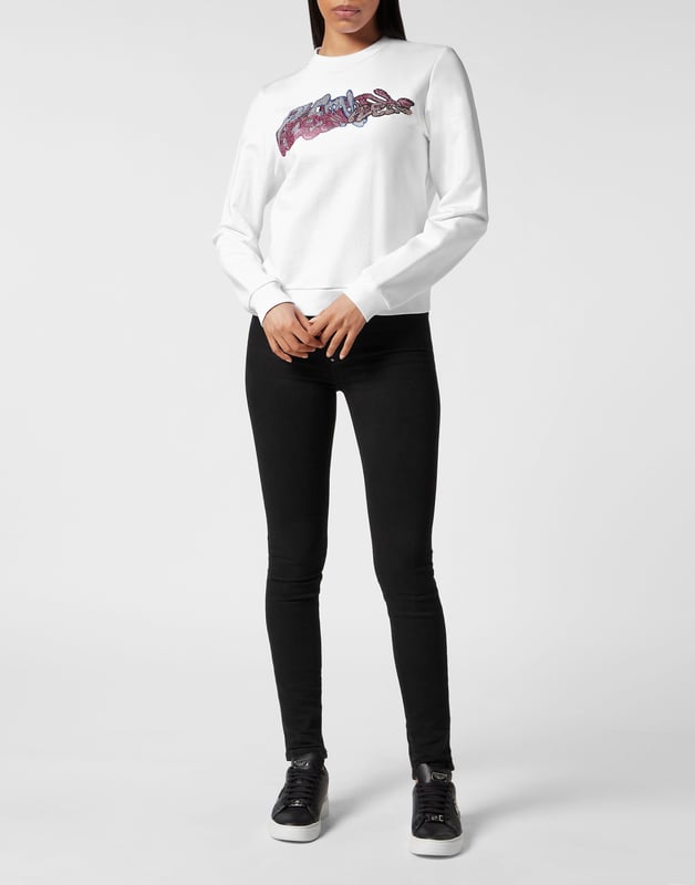 Define su estilo con un toque de personalidad. Eche un vistazo a este jersey de cuello redondo de tejido polar con detalles distintivos.   Suave forro polar de algodón  Estampado Bombing Graffiti multicolor con pedrería en la parte delantera   Hexágono de PP sobre una insignia de cuero saffian cosida en el canesú   Dobladillos de punto acanalado.   Ajuste: Regular