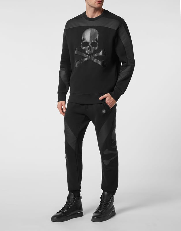 Mire lo original que es este jersey de cuello redondo de felpa de algodón decorado con el icónico Skull&bones de cuero sintético y aplicaciones en contraste. El hexágono de PP en un parche de cuero saffiano está cosido en el canesú. Dobladillos en punto de canalé.