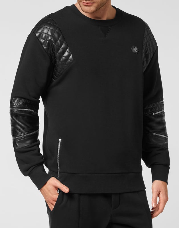 Mire lo original que es este jersey de cuello redondo de felpa de algodón decorado con aplicaciones de cuero sintético acolchado y cremalleras. El hexágono de PP en un parche de cuero saffiano está cosido en el lado izquierdo del pecho. Dobladillos en punto de canalé.