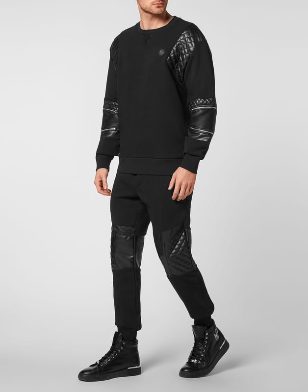Mire lo original que es este jersey de cuello redondo de felpa de algodón decorado con aplicaciones de cuero sintético acolchado y cremalleras. El hexágono de PP en un parche de cuero saffiano está cosido en el lado izquierdo del pecho. Dobladillos en punto de canalé.