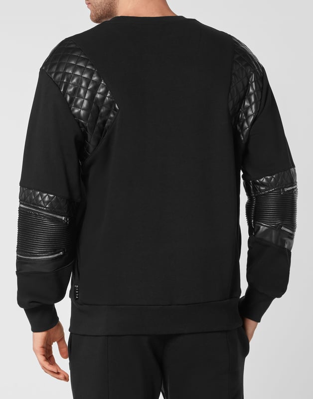 Mire lo original que es este jersey de cuello redondo de felpa de algodón decorado con aplicaciones de cuero sintético acolchado y cremalleras. El hexágono de PP en un parche de cuero saffiano está cosido en el lado izquierdo del pecho. Dobladillos en punto de canalé.