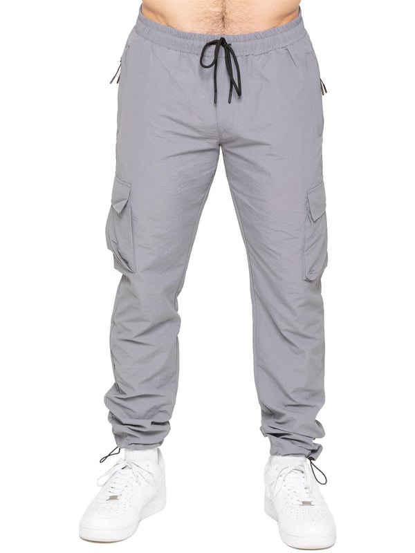 Stay ready for anything with the Enzo Milano Men’s Cargo Pants. Made from lightweight, poly fabric, these straight-leg trousers feature a regular fit, elasticated waistband with adjustable drawstring, and drawstring hems for a custom fit. With two Velcro-fastened side cargo pockets and a back welt pocket, they offer secure, practical storage. Perfect for everyday wear, travel, or outdoor use, these men’s cargo pants combine comfort, function, and style.