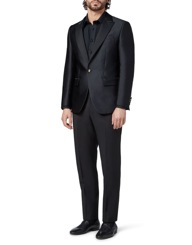 Special events need a dash of originality, like this single button evening jacket. It is made of viscose satin and acetate and decorated with the brand's iconic coat-of-arms embroidered on the back. Satin peak lapel and on pockets' flaps. Satin lined buttons with the brand's metal coat-of-arms. Two slits on the back. Inner lining.