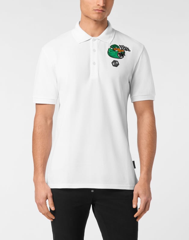 Discover the originality of this cotton piqué short sleeve polo shirt decorated with the Brand’s iconic elements.   Cotton piqué   Embroidered patch   Logoed patch sewn at left chest   Logoed buttons   Rib knit collar and cuffs    Two side slits