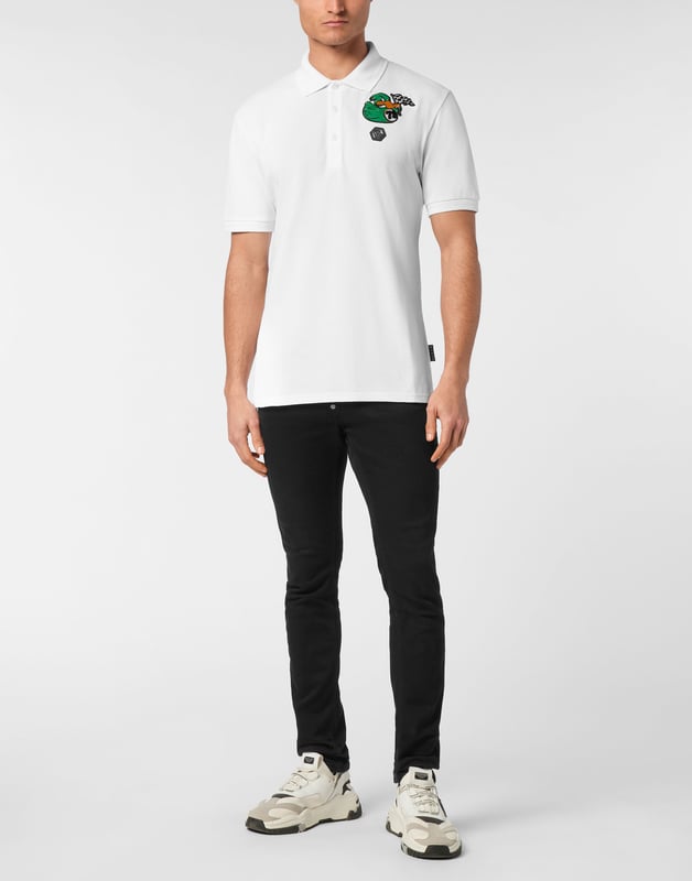 Discover the originality of this cotton piqué short sleeve polo shirt decorated with the Brand’s iconic elements.   Cotton piqué   Embroidered patch   Logoed patch sewn at left chest   Logoed buttons   Rib knit collar and cuffs    Two side slits