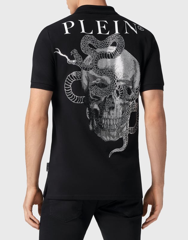 Descubra la originalidad de este polo de manga corta de algodón piqué decorado con peculiares dibujos.   Algodón piqué   Un estampado en la espalda representa dos serpientes entrelazadas entre la icónica calavera y la marca   Hexágono del PP en un parche de cuero saffiano cosido en el pecho izquierdo   Botones con logotipo   Cuello y puños de punto de canalé de chevron   Dos aberturas laterales